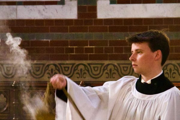 Thurifer censing congregation